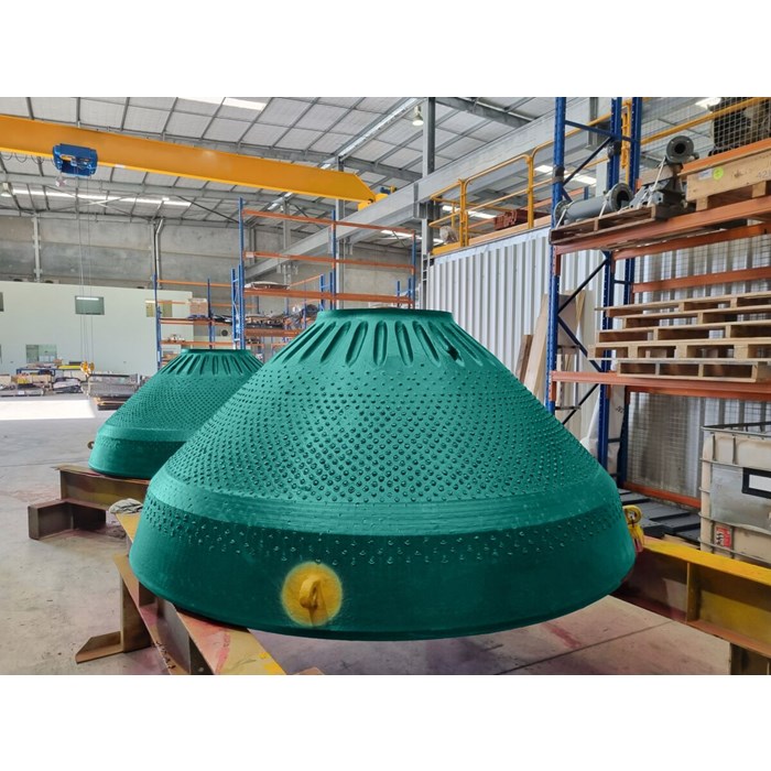 Metso Outotec experts next to crusher wear part