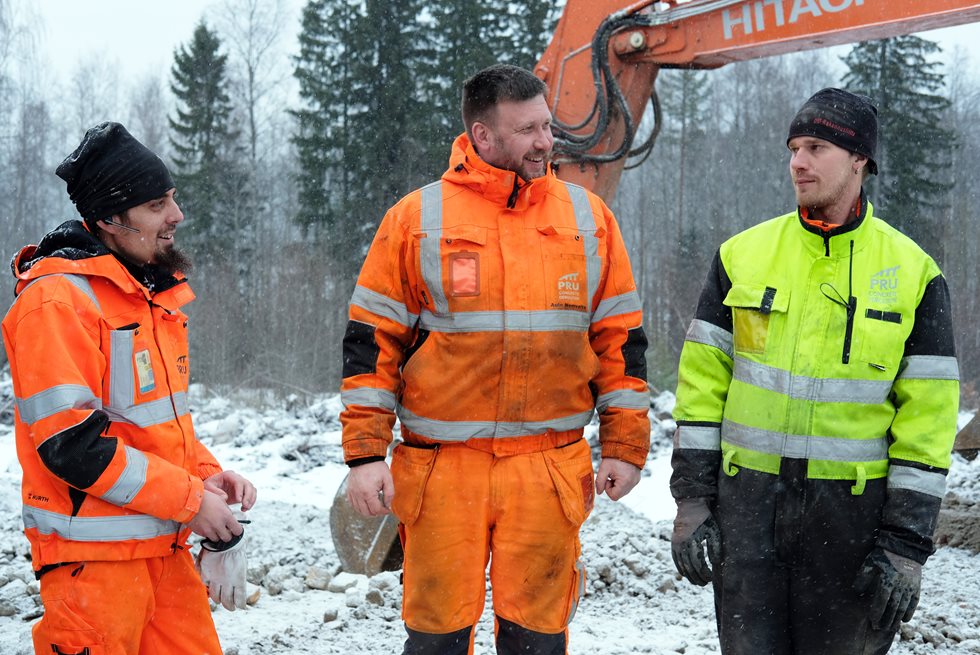 Three men talking in a wintery quarry scenery.