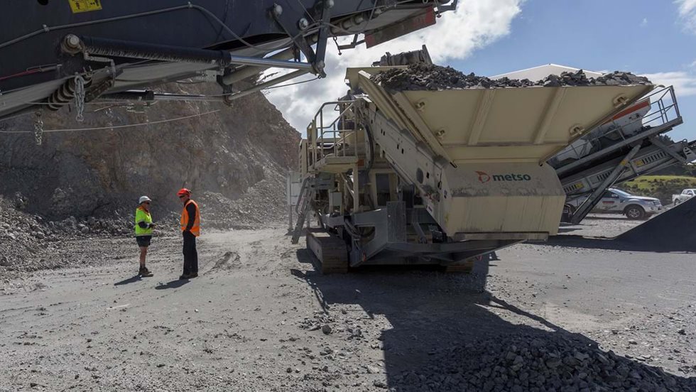 Two men next to Lokotrack mobile crusher.